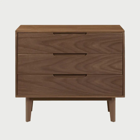 Vista frontal de la cómoda Talitha en color café nogal, destacando la profundidad del tono amaderado y la funcionalidad de sus tres cajones para la organización del dormitorio.