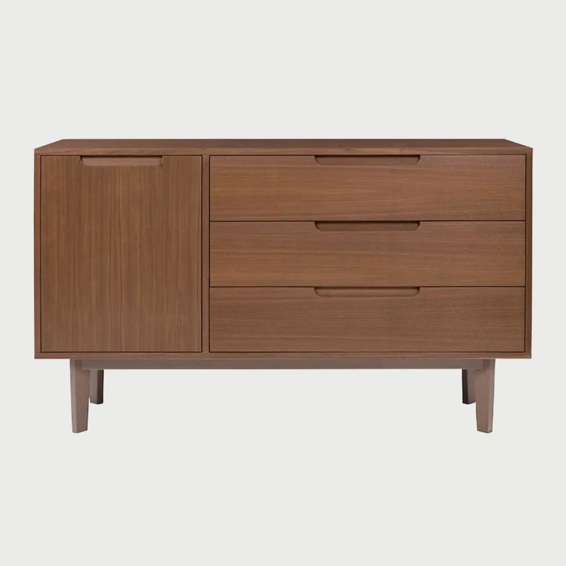 Vista frontal de la cómoda Talitha en acabado madera color café, con una configuración de tres cajones amplios a la derecha y una puerta vertical a la izquierda, todos con tiradores de muesca integrados.
