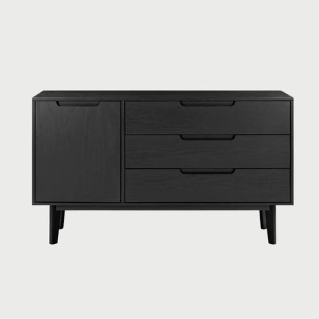 Vista frontal de la cómoda Talitha en color negro mate con tres cajones horizontales, destacando la veta de la madera bajo el acabado oscuro y tiradores tipo uñero.