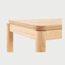 Acercamiento a la esquina de la consola Akari que resalta el acabado suave de la madera de encino, las vetas naturales visibles y el detalle de los bordes redondeados de la superficie