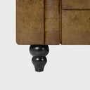 Primer plano de los botones tapizados y costuras del sofá Chesterfield Bogar café