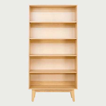 Vista frontal del librero Meztli en beige encino; presenta una sección izquierda de nichos abiertos tipo cuadrícula y una sección derecha con dos gabinetes superiores y dos cajones inferiores de frentes lisos.