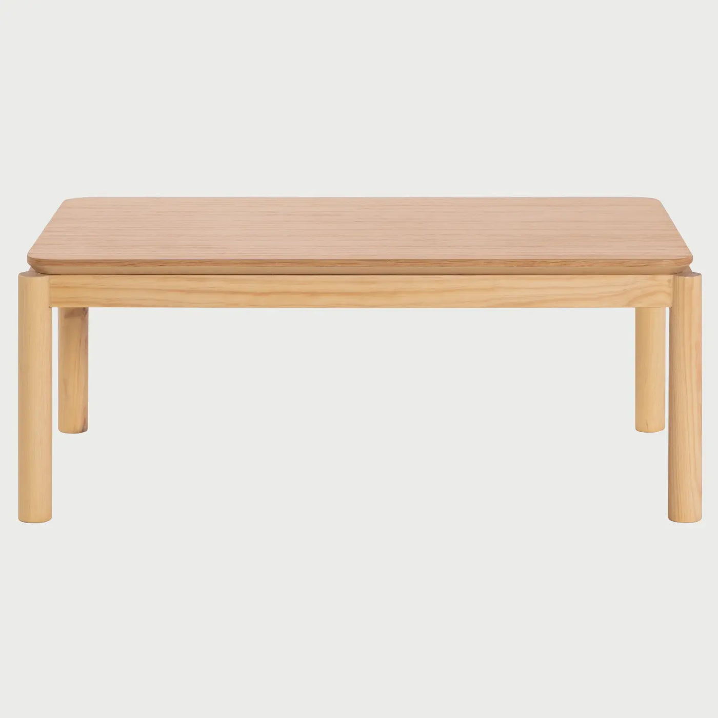 Vista frontal de la mesa de centro Akari de 100 cm; presenta una superficie rectangular de madera de encino en tono beige con esquinas redondeadas y cuatro patas cilíndricas robustas que ofrecen un soporte estable y limpio.