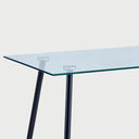 Acercamiento al herraje de sujeción circular que une la cubierta de cristal con las patas metálicas negras, resaltando la limpieza del diseño y la seguridad del ensamble.