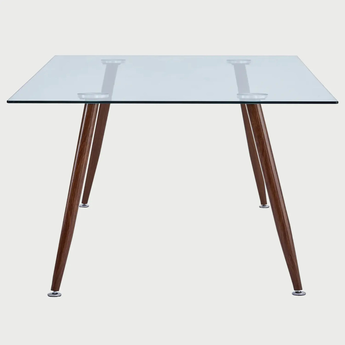Vista frontal de la mesa de comedor Amit de 160 cm en variante café; mantiene la cubierta de cristal templado pero con patas metálicas en acabado madera nogal para un toque más cálido.