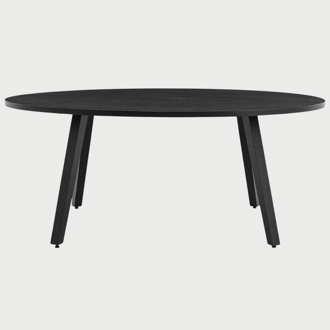 Vista frontal de la mesa de comedor ovalada Xocos en color negro; su acabado oscuro y monocromático enfatiza la silueta geométrica de las patas y la elegancia de la forma elíptica.