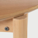 Acercamiento a la parte inferior de la mesa Akari; muestra la veta natural de la madera de encino y el detalle de la tornillería negra que asegura las patas a la estructura, garantizando durabilidad.