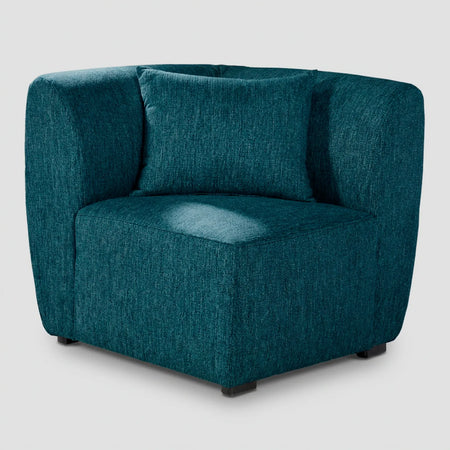 Vista frontal del módulo esquinero Kant GAIA en tela azul, mostrando su diseño cúbico sin brazos y el acolchado profundo del asiento y respaldo.