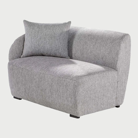 Vista lateral del módulo Kant GAIA con brazo izquierdo en tela gris, que muestra el perfil redondeado y envolvente del respaldo y la profundidad del asiento acolchado.