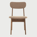 Vista frontal de la silla Marcela en color café, resaltando la armonía tonal entre el tapizado oscuro y la estructura de madera nogal de inspiración nórdica.