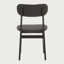 Vista posterior de la silla Marcela en acabado negro, destacando la superficie lisa del respaldo y la continuidad estética de su estructura de madera oscura.