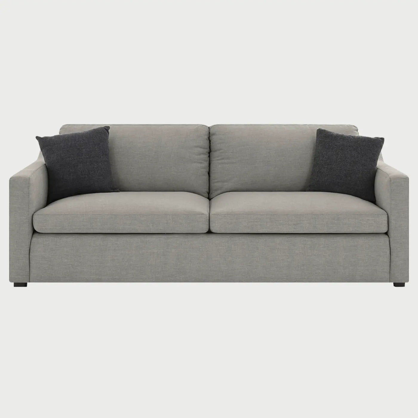 Vista frontal del sillón Marie de tres cuerpos en tela gris claro, destacando su silueta limpia y la organización proporcional de sus tres plazas con acentos textiles oscuros.