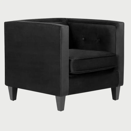 Vista lateral del sillón Moncayo GAIA en terciopelo negro, mostrando su estructura cúbica de líneas rectas, el brazo alto y las patas de madera oscura que elevan la pieza con elegancia.