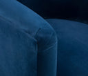 Sillón Tavari GAIA en terciopelo azul con brazos redondeados y un diseño moderno que invita al confort y la elegancia.