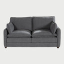 Vista frontal del sofá Andrea GAIA de dos cuerpos en tela gris, que muestra sus amplios cojines de asiento y respaldo tipo "puffy", descansabrazos rectos y patas de madera oscura.