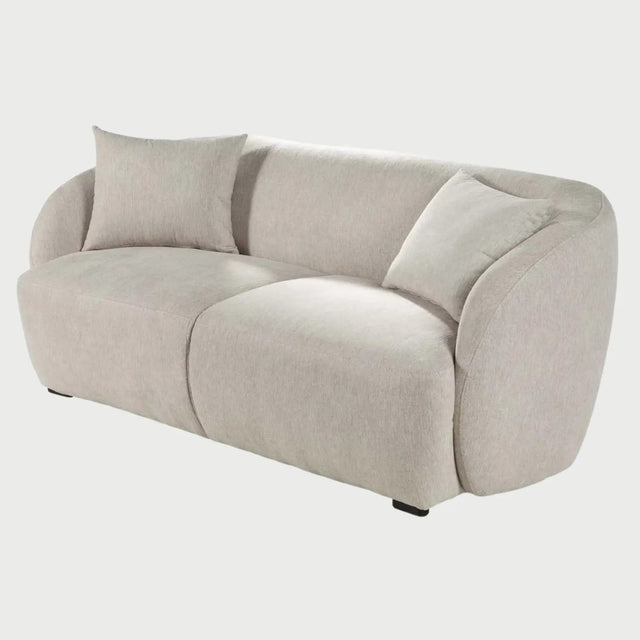 Vista lateral del sofá Kant de dos cuerpos en color blanco, destacando el perfil orgánico y continuo del respaldo hacia los descansabrazos, con una estructura de bajo perfil que acentúa su estilo minimalista.