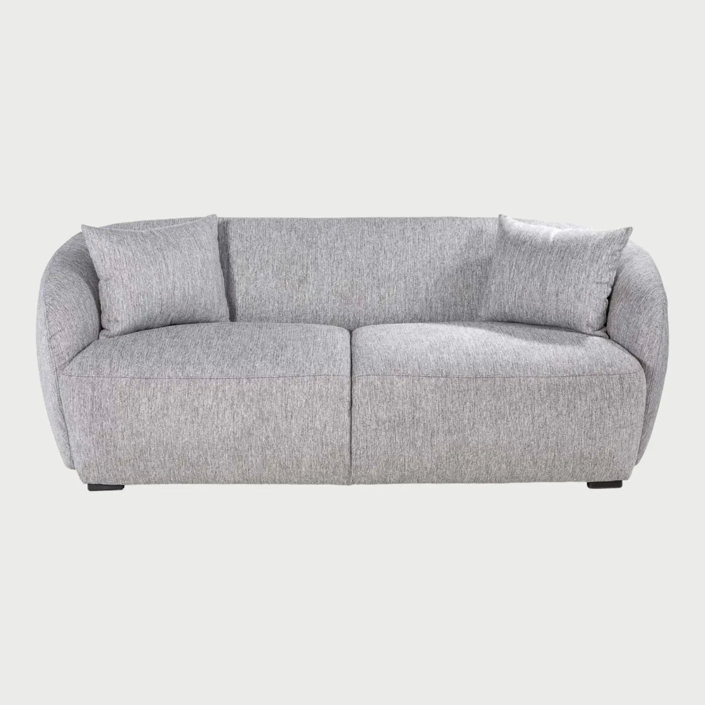 Vista frontal del sofá Kant de dos cuerpos en color gris, resaltando su silueta baja y contemporánea con cojines de respaldo mullidos y un diseño de base sólida.