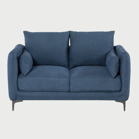 Vista frontal del sofá Marina GAIA de dos cuerpos en tela azul, con cojines de respaldo mullidos, cojines laterales decorativos y patas metálicas negras de diseño moderno.