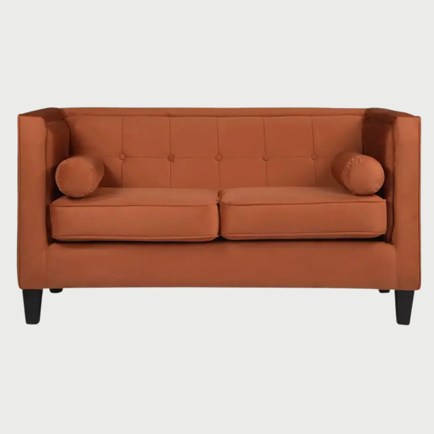 Sofá de dos cuerpos Moncayo GAIA tapizado en terciopelo naranja con respaldo capitonado, cojines tipo bolster y patas oscuras.