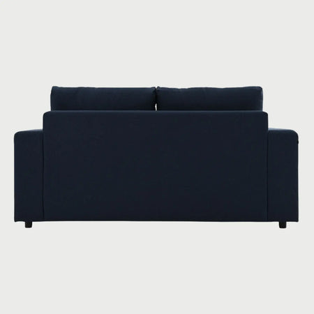Vista posterior del sofá Ocampos GAIA de 2 cuerpos tapizado en azul marino, resaltando el acabado liso del respaldo y la estructura moderna de soporte metálico.