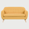 Sofá de dos cuerpos San Blas GAIA tapizado en tela amarilla con respaldo capitonado y patas cónicas de madera clara color encino.