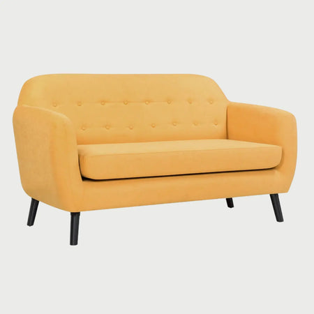 Vista lateral del sofá de dos cuerpos San Blas GAIA en tela amarilla, mostrando la curva fluida que integra el respaldo con los brazos y el soporte de las patas de madera inclinadas.