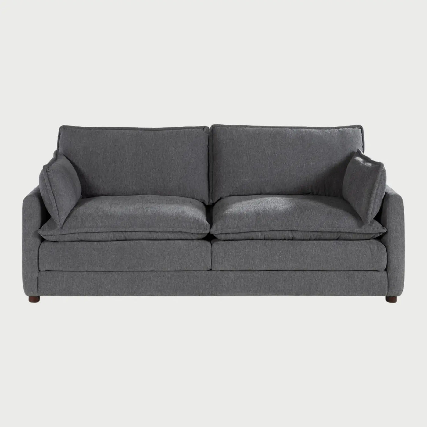 Vista frontal del sofá Andrea GAIA de tres cuerpos en tela gris, que muestra tres amplios cojines de asiento y respaldo con diseño acolchado tipo "puffy", descansabrazos rectos y patas de madera discretas.
