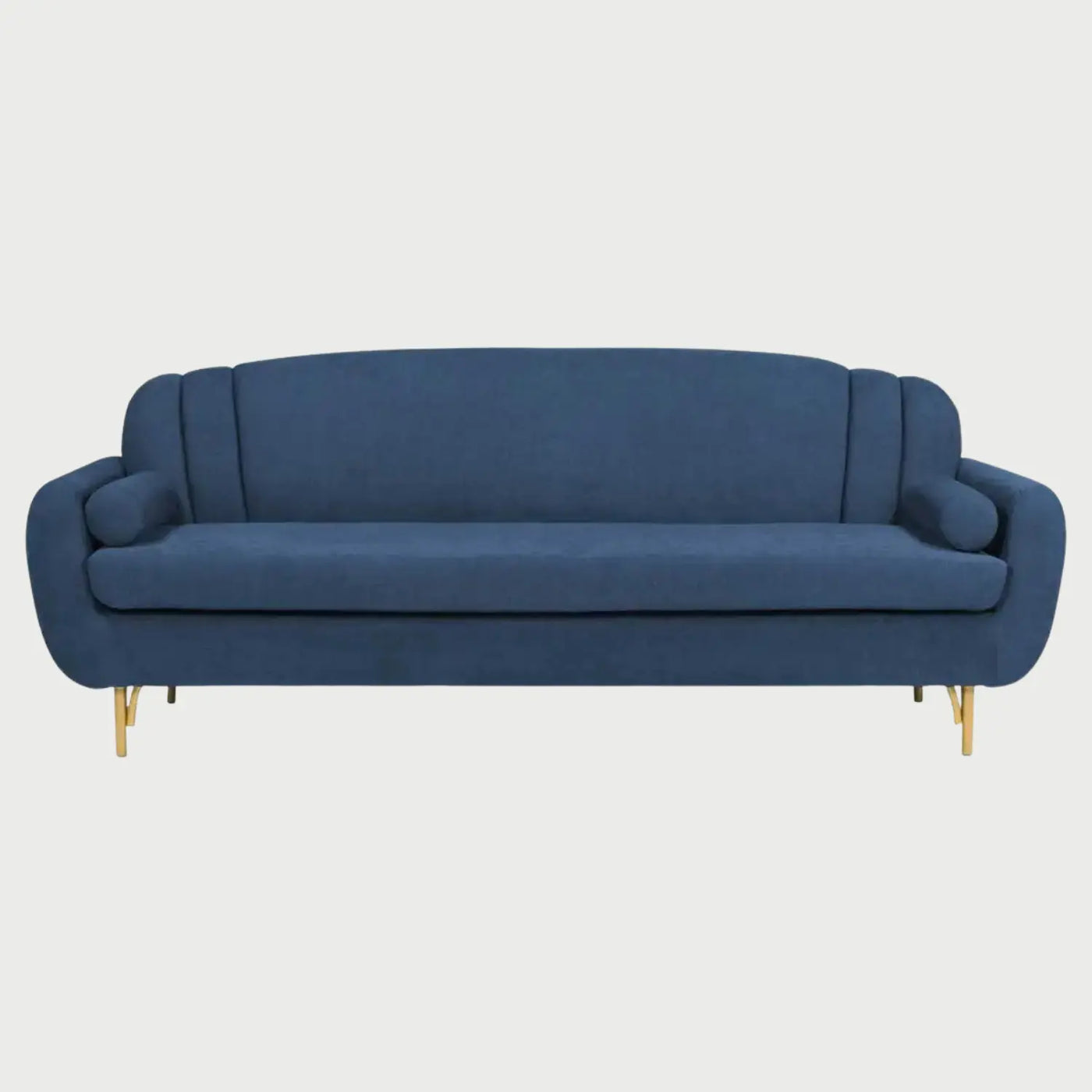 Sofá de tres cuerpos Basurto GAIA tapizado en tela azul con respaldo de silueta curva escalonada, cojines laterales cilíndricos y patas metálicas doradas.