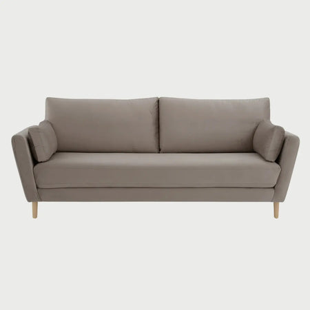 Vista frontal del sofá Levanto de tres cuerpos en color beige, destacando su estética cálida y moderna con patas de madera de encino y cojines laterales decorativos.