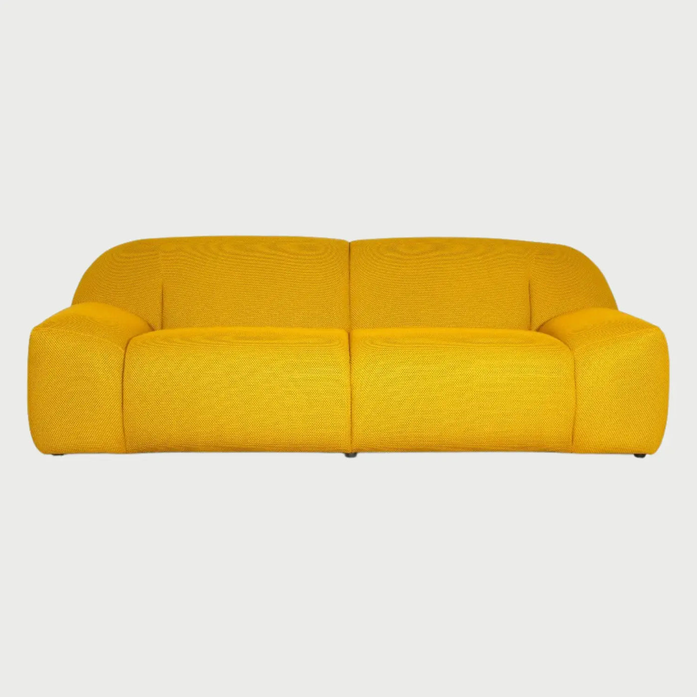 Vista frontal del sofá Marcus de tres cuerpos en color amarillo, mostrando su silueta contemporánea y acogedora en un tono vibrante que resalta sus formas redondeadas.