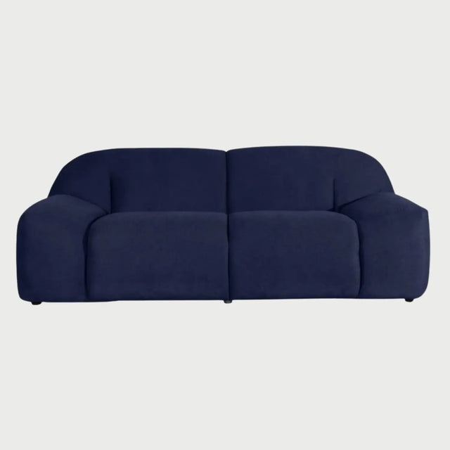 Vista frontal del sofá Marcus GAIA de tres cuerpos en tela azul marino, destacando su diseño robusto de bloques con asientos profundos, respaldos curvos y brazos anchos integrados que llegan hasta el suelo.