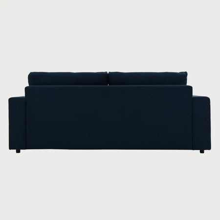 Vista posterior del sofá Ocampos de tres cuerpos en color azul, mostrando un acabado de tapicería liso y uniforme que permite lucir su diseño minimalista desde cualquier ángulo de la estancia.