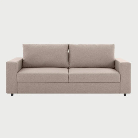 Vista frontal del sofá Ocampos de tres cuerpos en color beige, destacando su apariencia luminosa y la amplitud de sus cojines acolchados que brindan una estética acogedora y moderna.