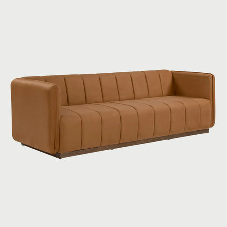 Vista lateral del sofá Porfirio naranja, resaltando el perfil rectangular de los descansabrazos y la continuidad del diseño de paneles verticales que envuelve la estructura sobre la base de madera oscura.