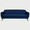 Vista frontal del sofá San Blas GAIA de tres cuerpos en tela azul oscuro, con respaldo capitoneado de botones, un solo cojín de asiento extendido y patas de madera en acabado nogal oscuro.