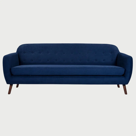 Vista frontal del sofá San Blas GAIA de tres cuerpos en tela azul oscuro, con respaldo capitoneado de botones, un solo cojín de asiento extendido y patas de madera en acabado nogal oscuro.
