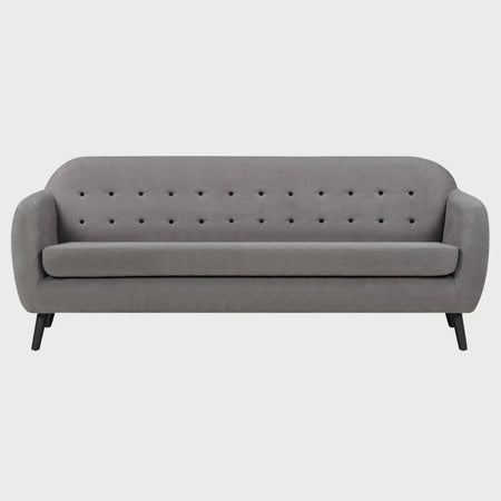 Vista frontal del sofá San Blas de tres cuerpos en color gris, resaltando su elegancia neutra y la amplitud del asiento acolchado soportado por patas de madera oscuras.