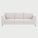 Vista frontal del sofá Yoco de tres cuerpos en tela blanca, con tres cojines de respaldo, tres cojines de asiento y patas de madera en acabado negro que aportan un contraste moderno y minimalista.