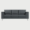 Vista frontal del sofá Yoco de tres cuerpos en color gris oscuro, resaltando el contraste entre el tapizado profundo y las estilizadas patas metálicas negras.