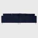 Vista posterior del sofá Yoco de cuatro cuerpos en terciopelo azul, con un acabado de tapicería liso y continuo que exhibe la gran escala de la pieza y su soporte metálico dorado.