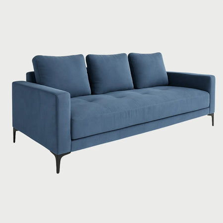 Perfil lateral del sofá cama Arriaga azul, resaltando el diseño recto de los descansa brazos y la profundidad del asiento acolchado.