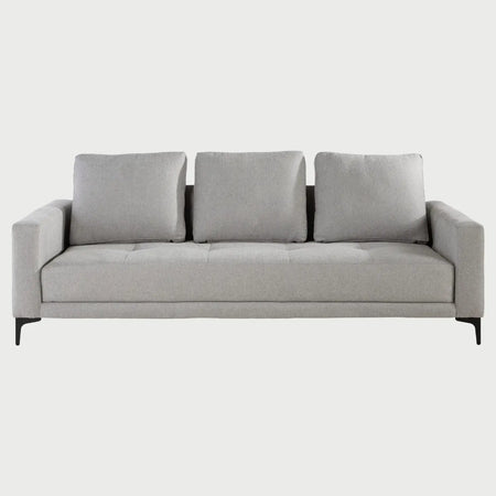 Vista frontal del sofá cama Arriaga en gris claro, resaltando su versatilidad decorativa y líneas minimalistas.