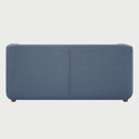 Vista posterior del sofá cama Basil en color azul, mostrando un tapizado liso y uniforme con soporte de patas de madera oscura.