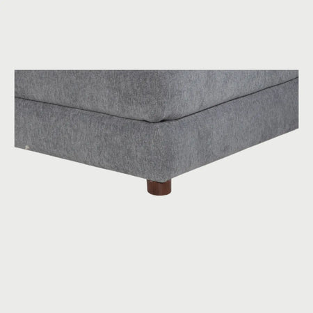 Acercamiento al taburete Andrea en color gris que muestra la textura de la trama textil y el acabado mullido del cojín superior, diseñado para ofrecer una experiencia de descanso premium.