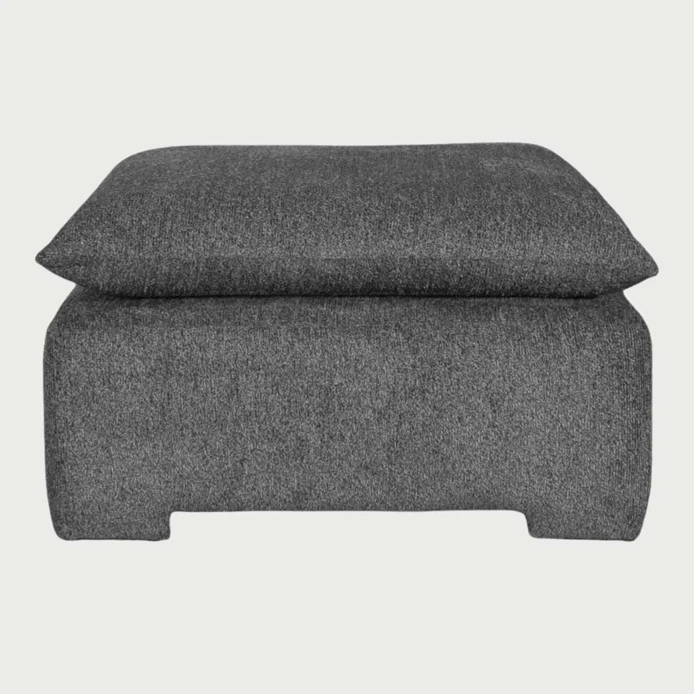 Vista frontal del taburete Ani tapizado en tela de trama cerrada color gris medio, destacando su cojín superior de gran volumen y su base sólida integrada que proporciona una apariencia de confort absoluto.