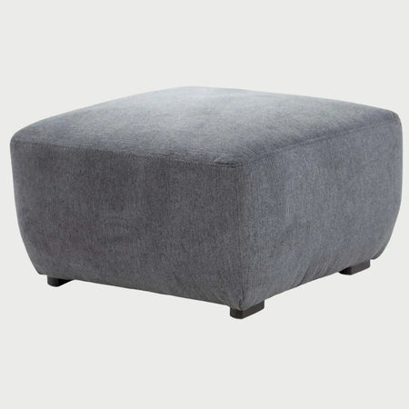 Vista frontal del taburete Kant tapizado en tela de trama cerrada color gris medio, con una silueta cuadrada de bordes redondeados y una estructura compacta totalmente acolchada.