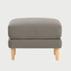 Vista frontal del taburete Levanto en color beige, con un diseño de cojín superior acolchado de bordes rectos y base elevada sobre patas de madera clara en acabado encino.