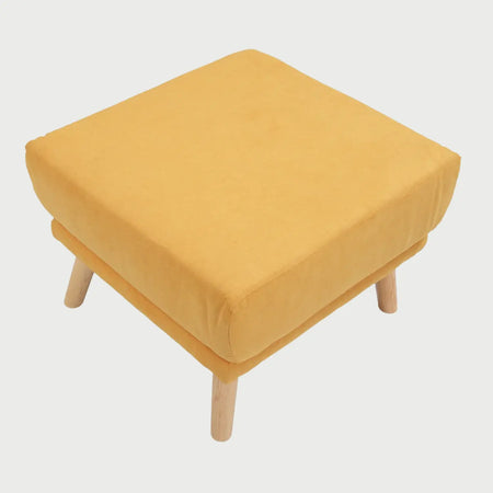 Vista lateral del taburete San Blas amarillo, mostrando el perfil acolchado del asiento y la inclinación de las patas de madera de encino que aportan un estilo nórdico.