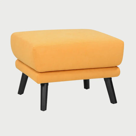 Vista lateral del taburete San Blas amarillo, mostrando el perfil del cojín acolchado y la inclinación de sus patas oscuras que aportan estabilidad y un estilo moderno.