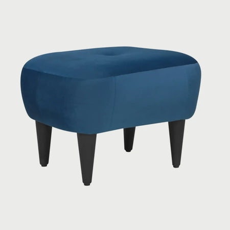 Vista lateral del taburete Tavari azul, mostrando el perfil redondeado y acolchado de su estructura, diseñado para aportar suavidad visual y confort en espacios compactos.